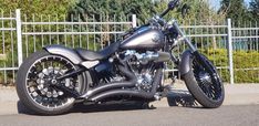 a black motorcycle parked next to a fence