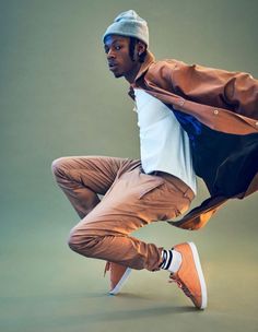 a man is dancing in the air with his jacket over his head and shoes on