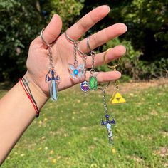 a person's hand holding several different key chains