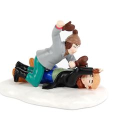 a figurine is laying down on the ground with a woman holding her head