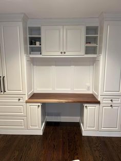 a kitchen with white cabinets and wood flooring