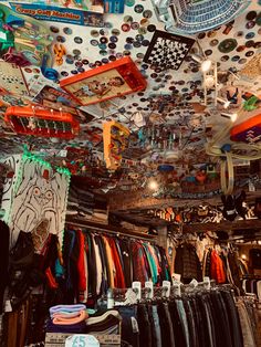 there are many different items hanging from the ceiling in this store, including shirts and ties