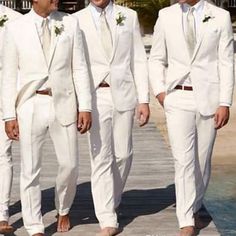 three men in white suits standing next to each other on a dock near the water