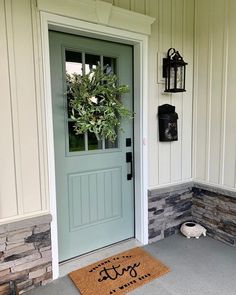 a door mat that says dog on it next to a front door with a potted plant