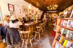 two women are sitting at the bar in a restaurant with many books on the shelves