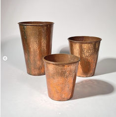 three copper colored cups sitting next to each other