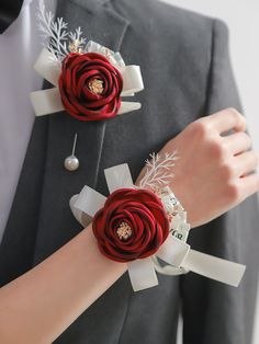 two red roses are attached to the wrist of a man in a suit and tie