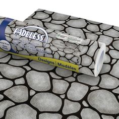 a tube of toothpaste sitting on top of a rock pattern table cloth that has been designed to look like pebbles