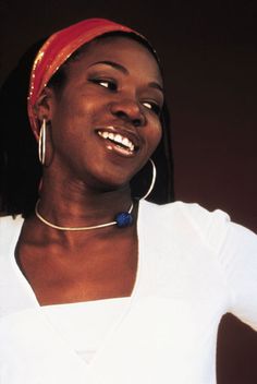 a woman in white shirt and red headband smiling