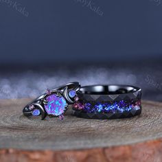 two black rings with purple and blue opal inlays sitting on top of each other