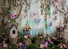 the backdrop is decorated with pink flowers, butterflies and birdcages for a birthday party