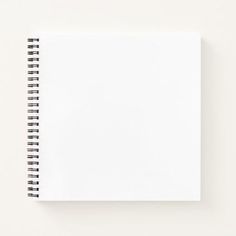 an open spiral notebook sitting on top of a white table