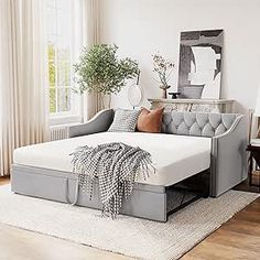 a living room with a couch, chair and rug on the floor in front of a window