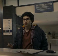 a man standing in front of a desk with a laptop computer on it