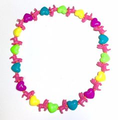 A herd of magical unicorns prance among colorful hearts! The base of the necklace is a 20-inch strong and stretchy elastic jewelry cord. All beads are plastic. Elastic Jewelry, Colorful Hearts, Rainbow Hearts, Bright Rainbow, Magical Unicorn, Pink Unicorn, Rainbow Heart