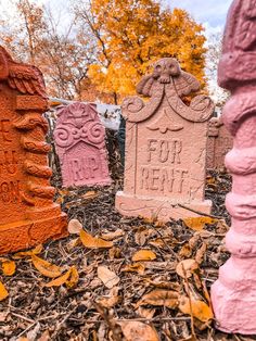 three cement headstones with the words for rent carved into them in front of trees