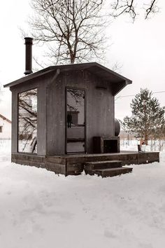 an outhouse in the snow with stairs leading up to it