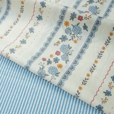 the fabric is blue and white with flowers on it's side, along with stripes