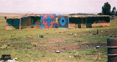 there is a building that has been painted blue, red and orange in the grass