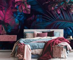 a bedroom decorated in pink, blue and purple colors with tropical leaves on the wall