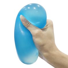 a hand holding a blue balloon in front of a white background with the ball being held up to it's face