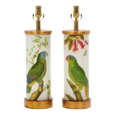 two green parrots sitting on top of a wooden stand next to each other,