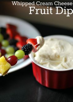 whipped cream cheese fruit dip in a red bowl with grapes and pineapples on the side