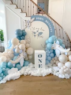 balloons and decorations are arranged on the floor in front of an entrance to a staircase