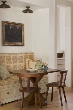 a table with two chairs and a bench in the middle of a living room area