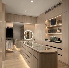 a modern dressing room with wooden cabinets and lights on the wall, along with an oval mirror