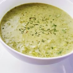 a white bowl filled with broccoli soup on top of a table