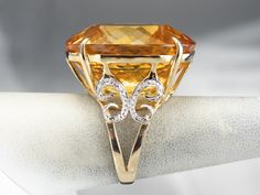 This citrine cocktail ring is sure to turn heads! This whopping gem sparkles with sunshine hues and undertones of honey, perfectly paired with warm yellow gold. Swirling diamond accents add even more glamour to this statement ring! Metal: 14K Yellow and White Gold Gem: Citrine Gem Measurements: 22.3 x 26.2 mm, Oval Accents: 8 Diamonds totaling .04 Carats Ring Size: 6.75 Marks: "14K 585" Stamped on the inside band Gold Cocktail Ring, Warm Yellow, Gold Cocktail, Watch Chain, Color Analysis, Diamond Gold, Ring Metal, Cocktail Ring, Pearl Pendant