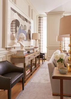 a living room filled with furniture and a painting on the wall over a coffee table