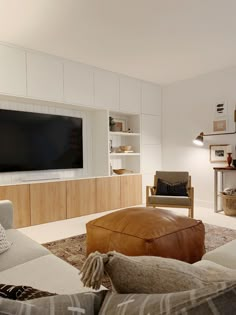 a living room filled with furniture and a flat screen tv mounted to the side of a wall