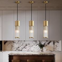 a kitchen with marble counter tops and gold pendant lights hanging from the ceiling above it