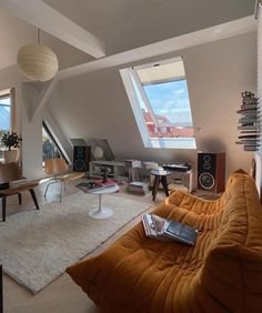 a living room filled with lots of furniture next to a tall window covered in skylights