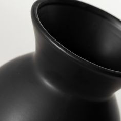 a black vase sitting on top of a white table