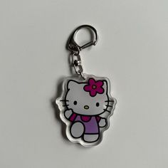 a hello kitty keychain with a pink bow on it's back end