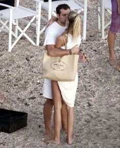 a man and woman hugging on the beach