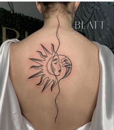 a woman's back with a sun tattoo on it