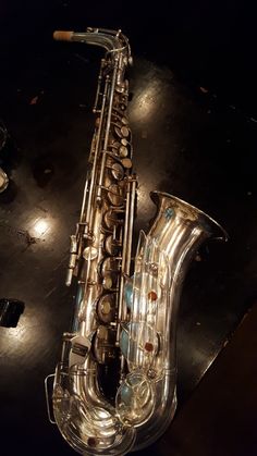 a silver saxophone sitting on top of a table