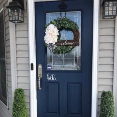 a blue front door with a welcome sign on it