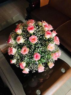 a bouquet of flowers sitting on top of a table next to a brown leather chair