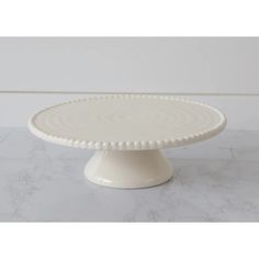 This farmhouse-inspired cake stand is perfect for your cottage kitchen. Enjoy your favorite desserts on this 9" diameter beaded-edge white cake stand- a great mix of modern and classic. Size: 3" H x 9" Dia Material: Dolomite Condition: New Beaded Cake Stand, Beaded Cake, Elegant Cake Stands, White Cake Stand, Painted Spoons, Rustic Dinnerware, Beautiful Cake Stands, Elegant Cake, Oak Cabinet