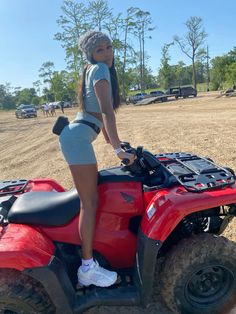 a woman standing on top of an atv