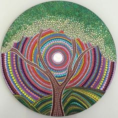 a circular painting with an abstract tree in the center and colorful circles on the bottom