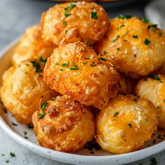 a white bowl filled with cheesy potatoes on top of a table