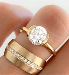 a woman's hand with two gold rings and a diamond