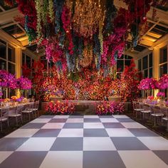 a checkered floor with flowers and chandeliers hanging from it's ceiling