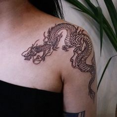 a woman with a dragon tattoo on her shoulder